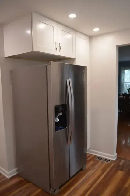 A stainless steel refrigerator with a water dispenser in a kitchen