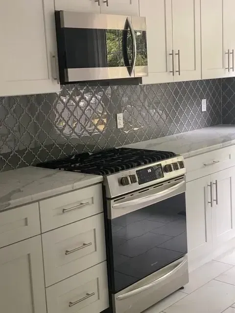 A kitchen with stainless steel appliances and white cabinets
