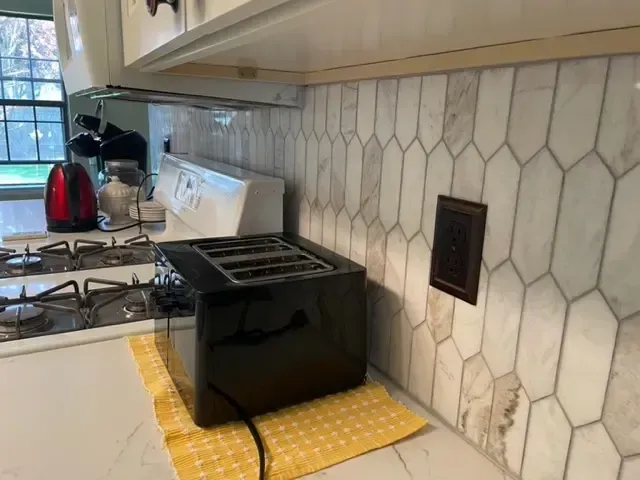 A toaster oven is sitting on a kitchen counter next to a stove.