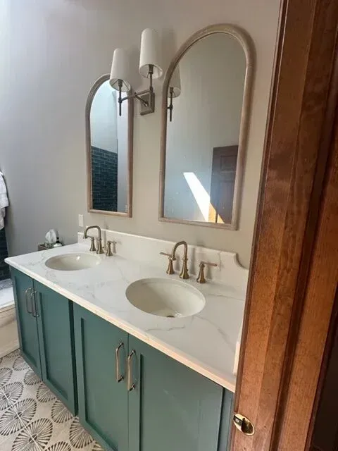 A bathroom with two sinks and two mirrors.