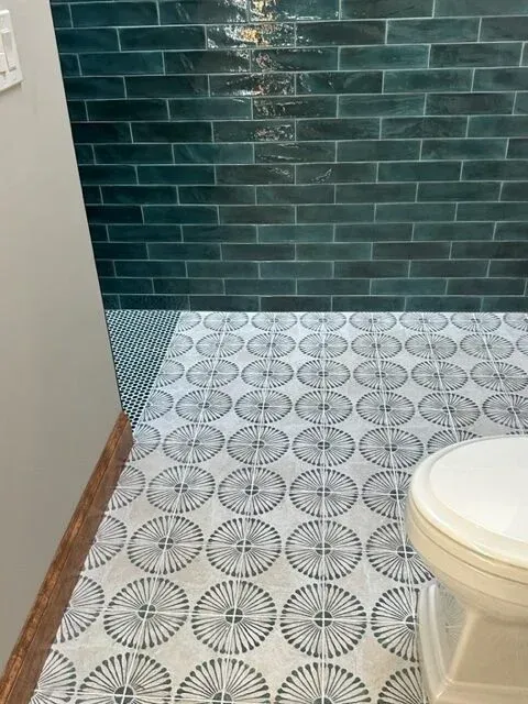 A bathroom with a toilet and a tiled floor.