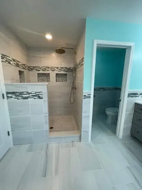 A bathroom with a walk in shower and a toilet.