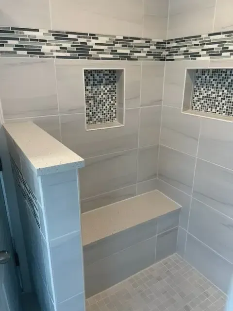 A shower with a bench and two niches on the wall.