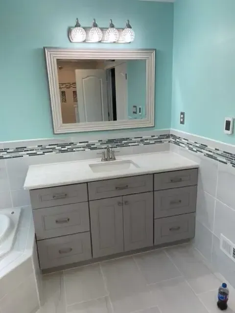 A bathroom with a sink and a mirror above it