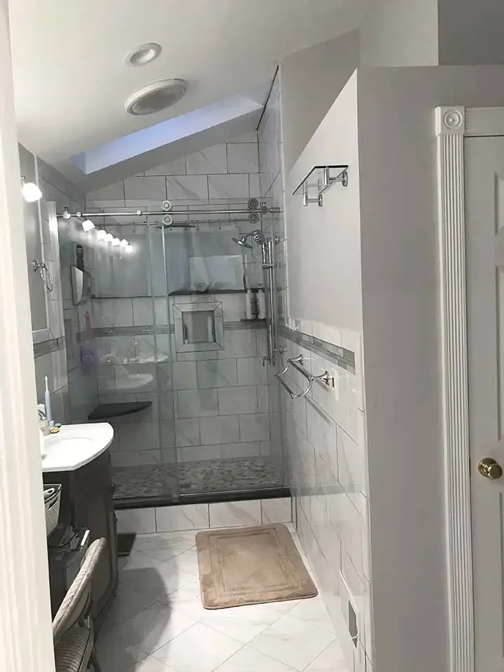 A bathroom with a walk in shower and a sink.