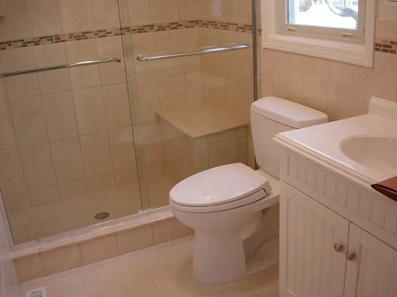 A bathroom with a toilet a sink and a shower