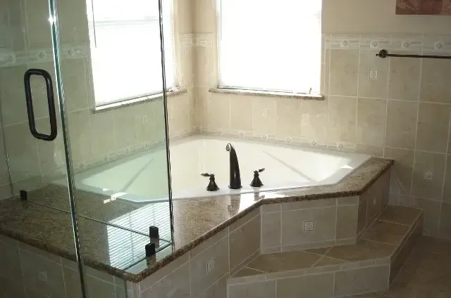 A bathtub in a bathroom with a glass door