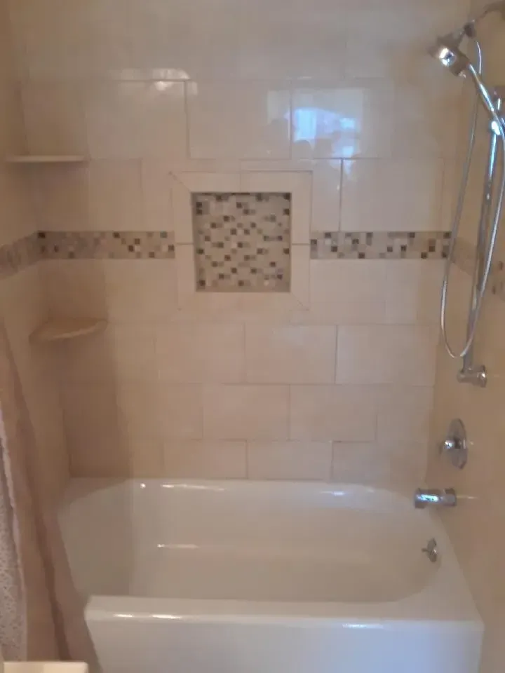 A bathroom with a bathtub and a shower head.