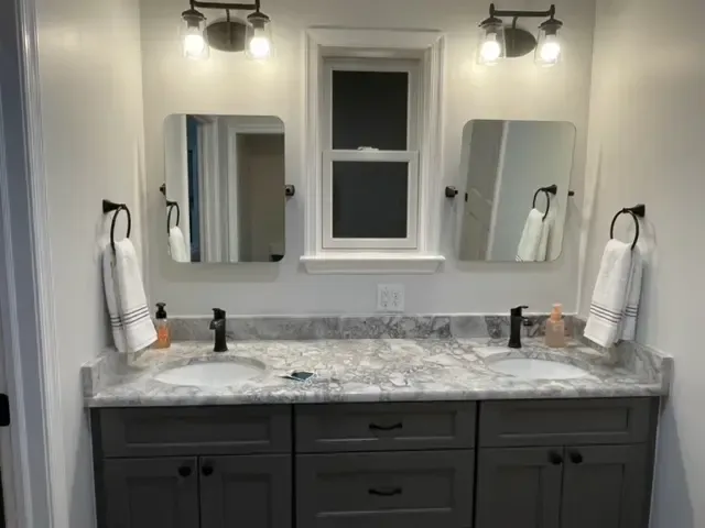 A bathroom with two sinks and two mirrors.
