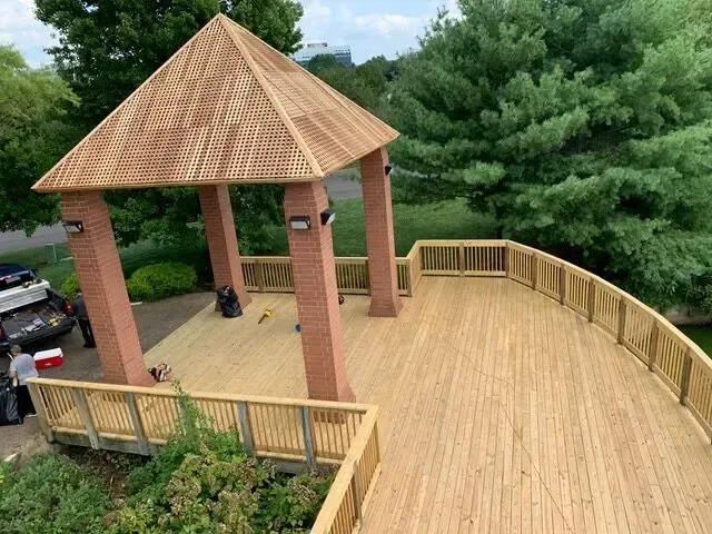 A wooden deck with a gazebo in the background