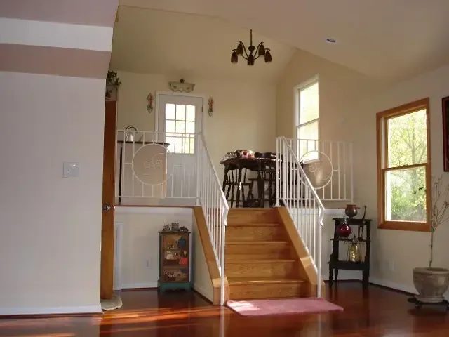 A living room with stairs leading up to a balcony