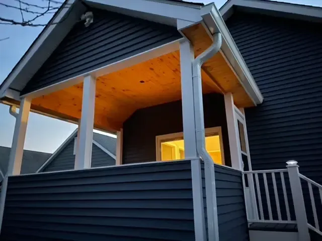 A black house with a porch and stairs