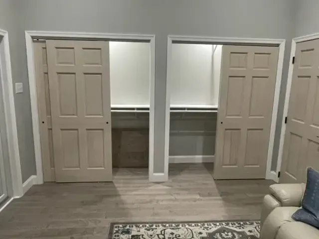 A living room with two closets and a couch.