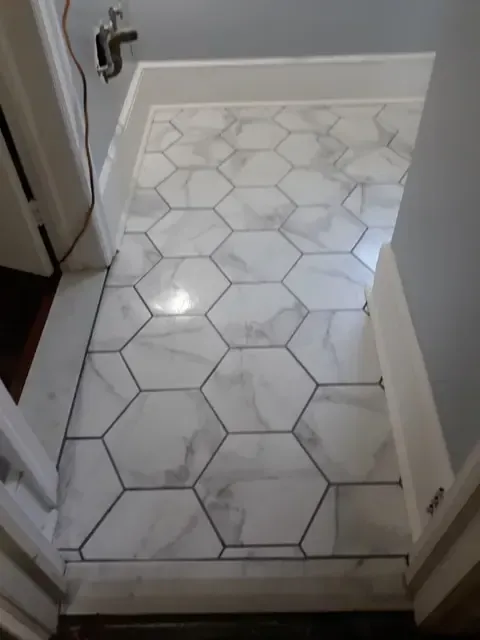 A bathroom with a hexagonal tile floor