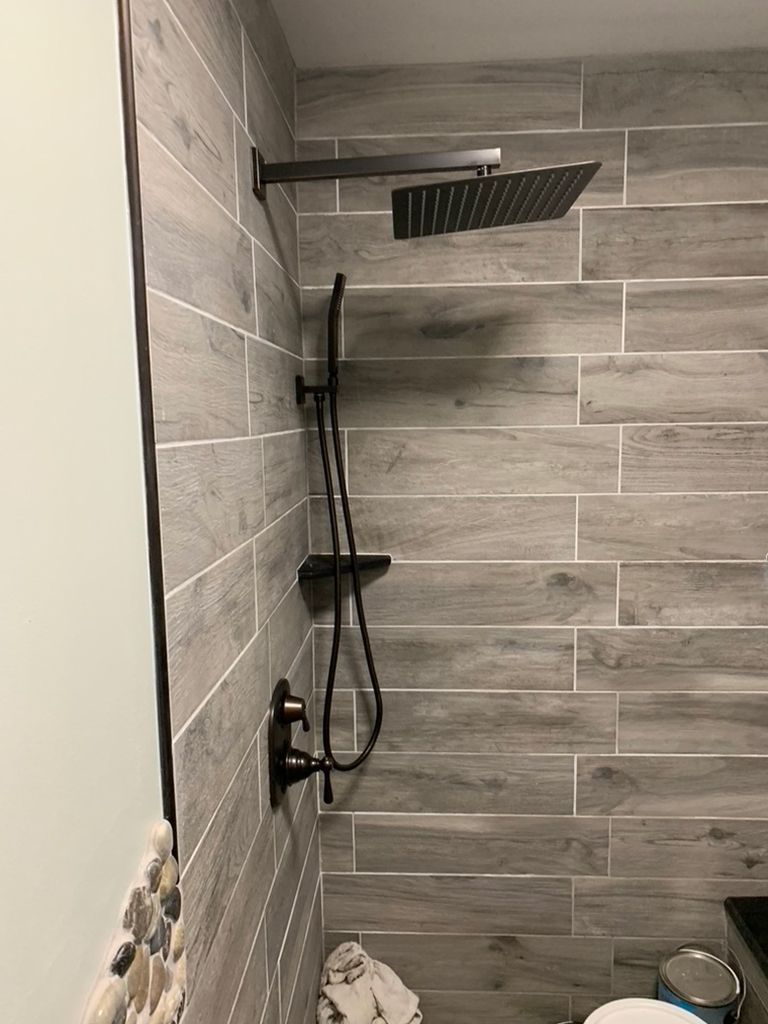 A bathroom with a shower head and a toilet.