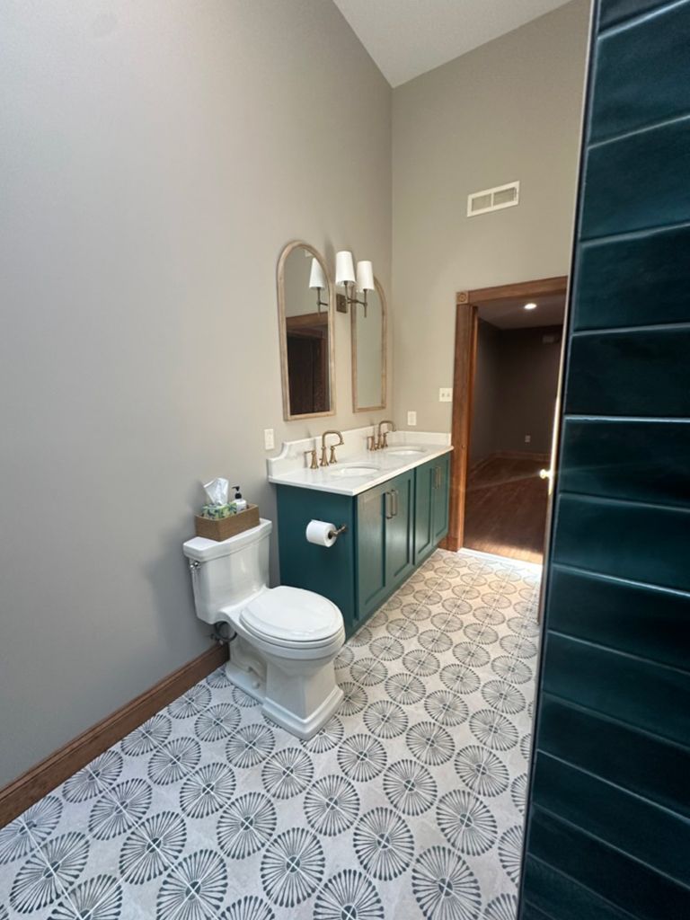 A bathroom with a toilet , sink and mirror.