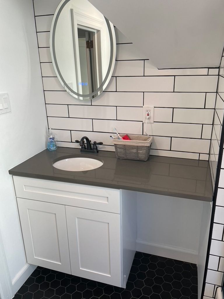 A bathroom with a sink and a mirror on the wall.