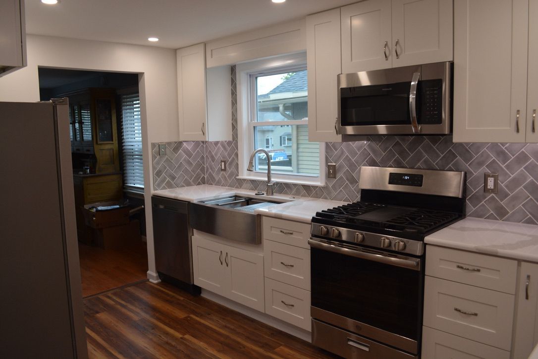 A kitchen with stainless steel appliances and white cabinets.