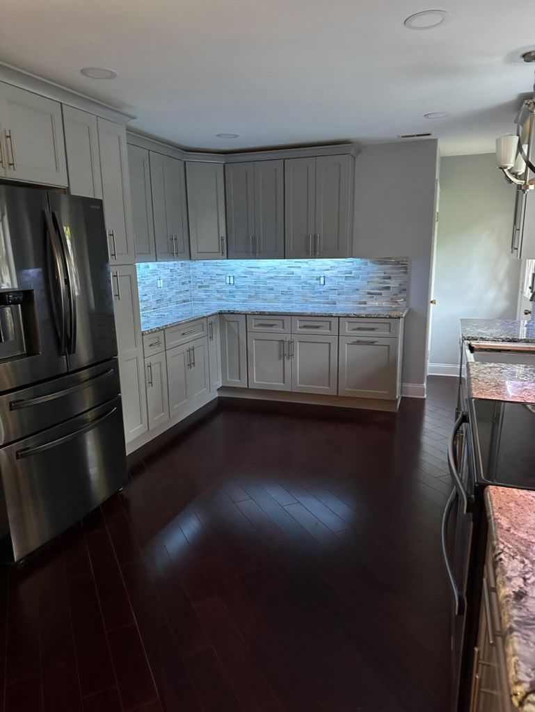 A kitchen with stainless steel appliances and white cabinets.