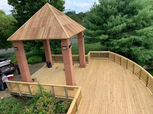 A wooden deck with a gazebo in the background.