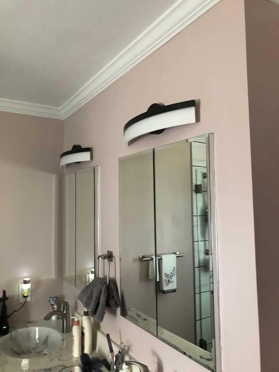 A bathroom with two mirrors and a sink