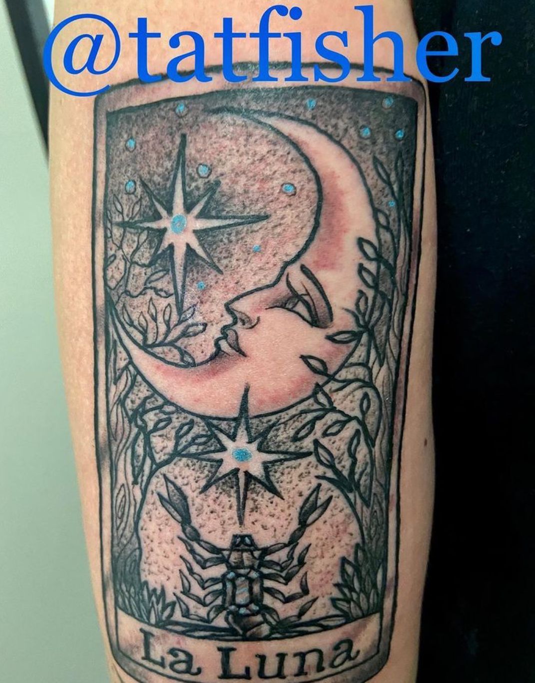 Tattoo: La Luna tarot card with moon face, stars, scorpion, and foliage.  Black ink and pastel colors.