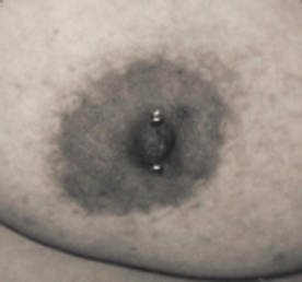 Close-up of a nipple with a horizontal barbell piercing, surrounded by a dark areola.