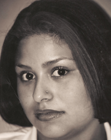 Woman with a nose piercing looks directly at the camera with a serious expression. Sepia toned photo.