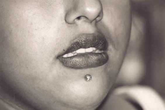 Close-up of a person's face, focusing on the lower lip and chin with a lip piercing.