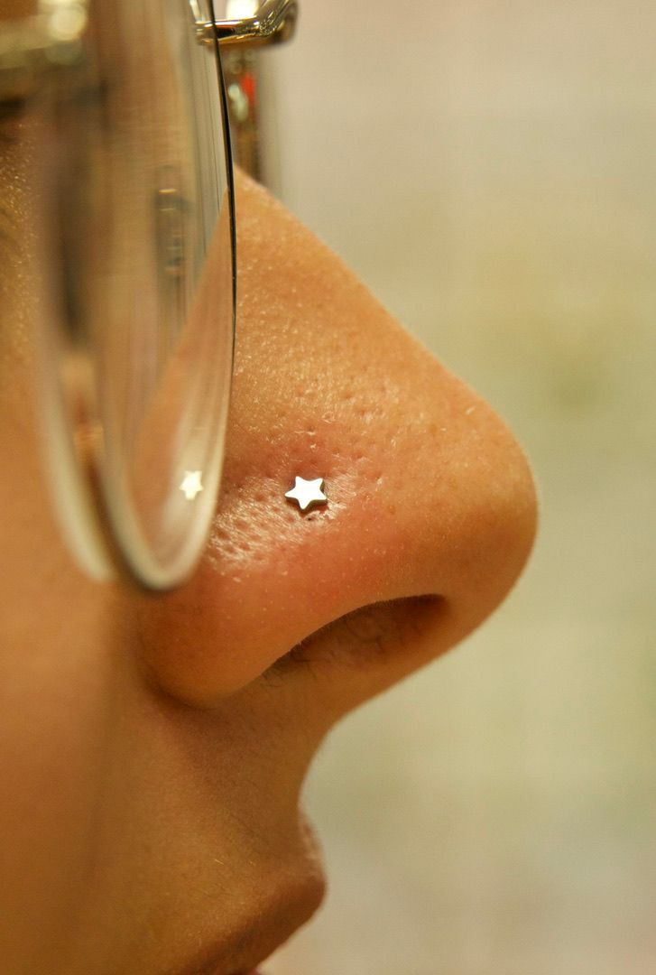 Nose piercing: A side view of a nose with a star-shaped stud piercing near the nostril.