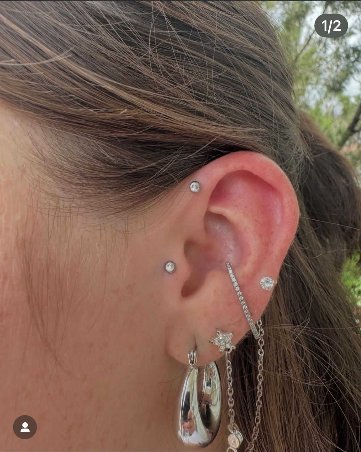 Ear with multiple piercings and silver jewelry.