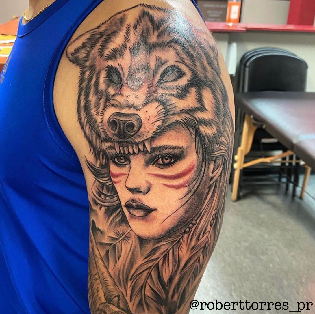 Tattoo of a woman wearing a wolf headdress. Black and gray ink. Red face paint.