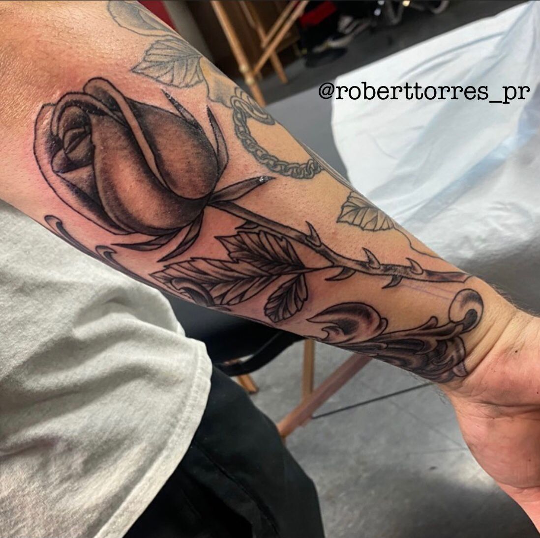 Black and gray rose tattoo on a forearm.