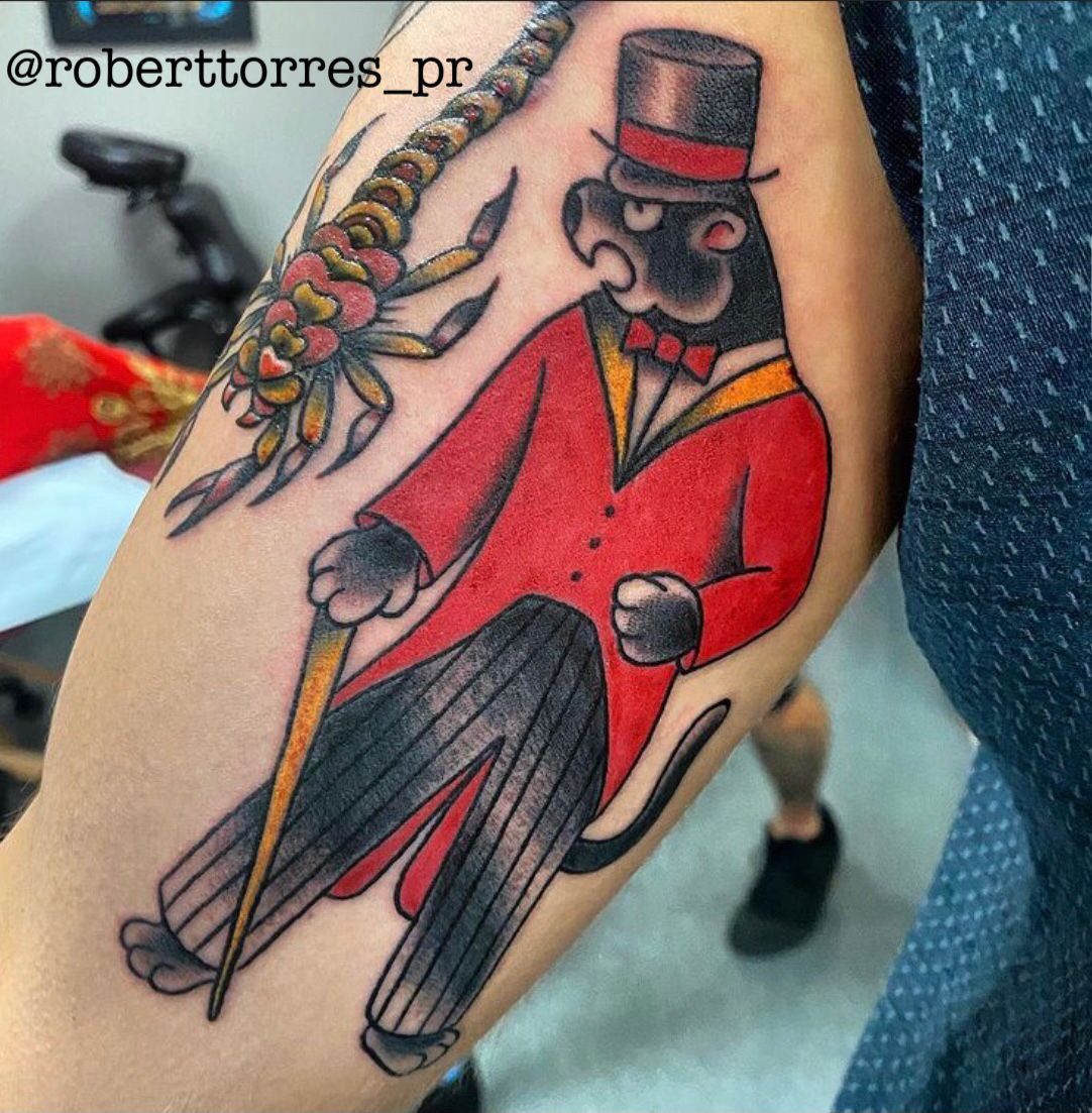 Tattoo of a black panther in red suit and top hat holding a cane; next to a scorpion.