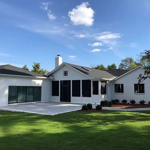 A large white house with a large lawn in front of it