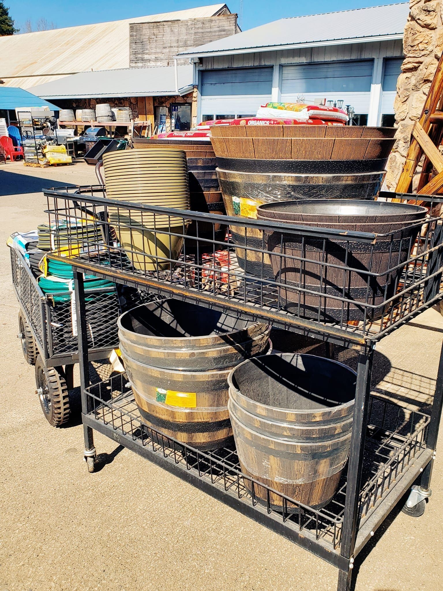 Metal cart displaying various wooden planters and pots outdoors.