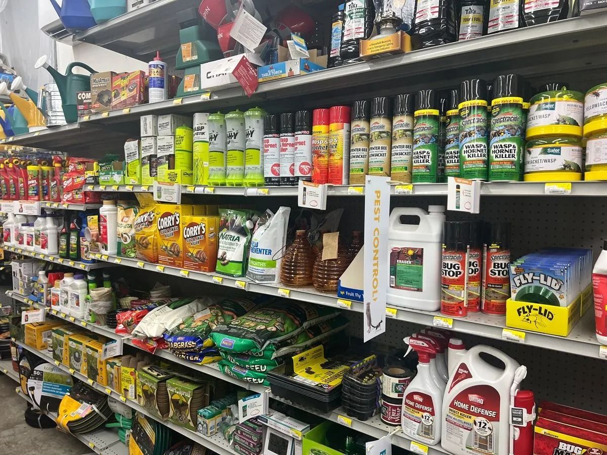 Shelves stocked with gardening supplies including fertilizers, weed killers, and seed, in a store.