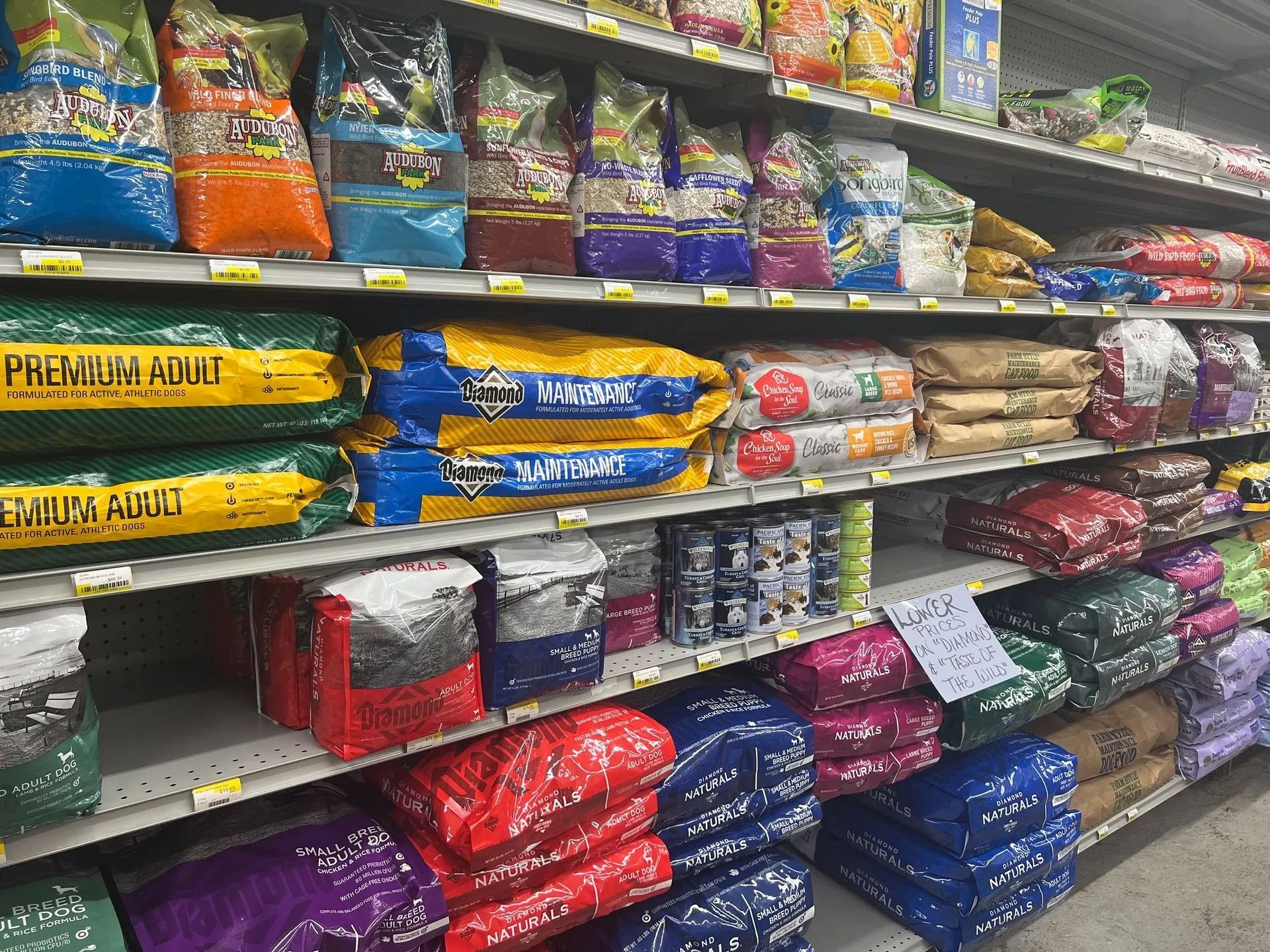 Shelves of dog food bags in a pet supply store; various colors, brands, and sizes are visible.