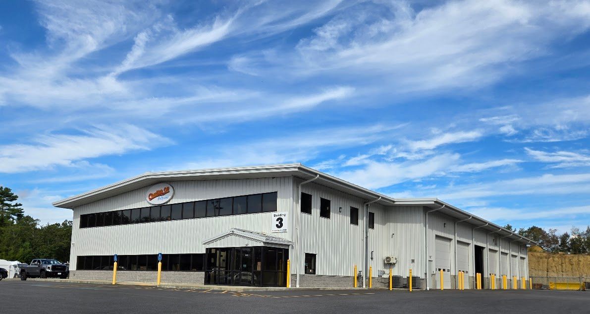 Building with red logo under blue sky with clouds.