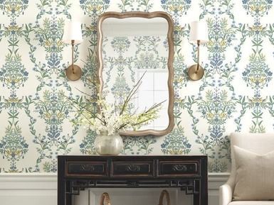 Living room with floral wallpaper, a mirror, sconces, and a black table.