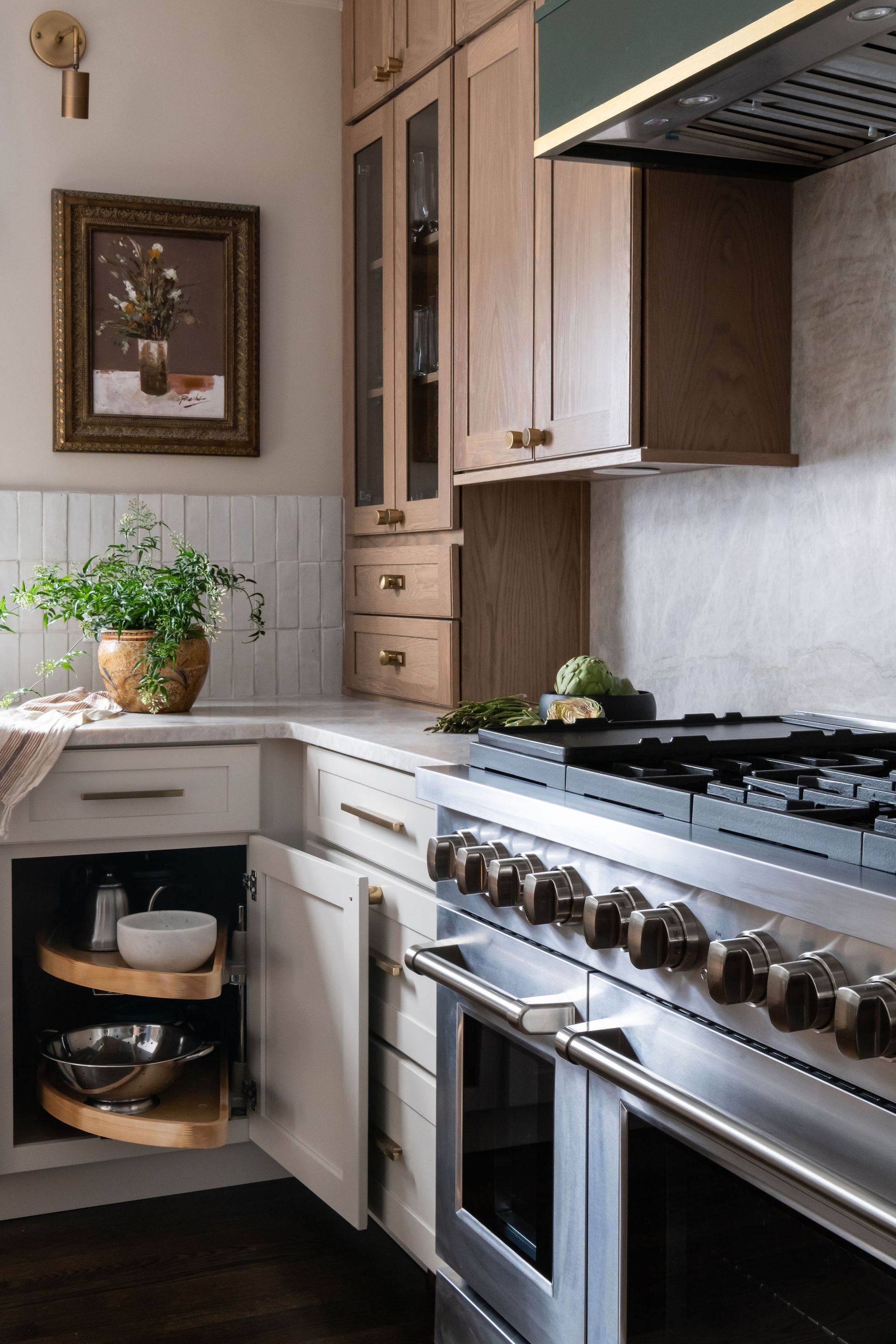 Kitchen with light wood cabinets, stainless steel range, and pull-out shelving.