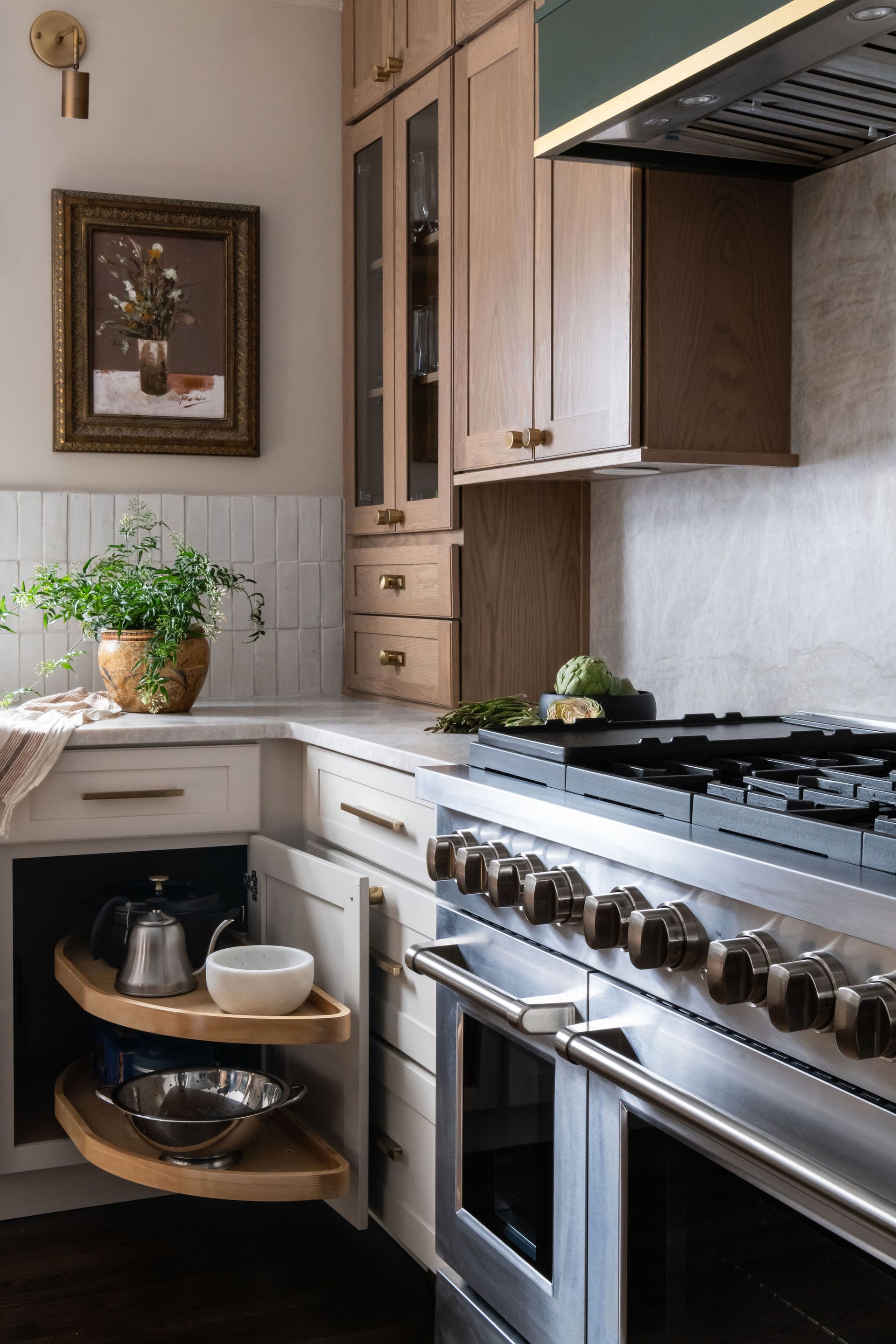 A stylish kitchen with light wood cabinets, stainless steel range, and a corner cabinet with pull-out shelves.
