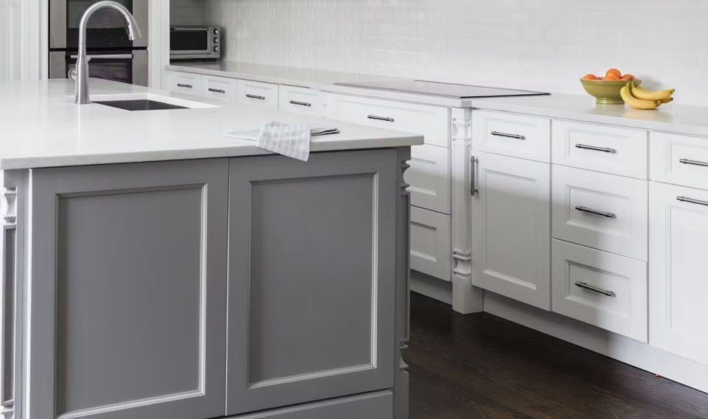 Gray and white kitchen with a large island and white countertops.