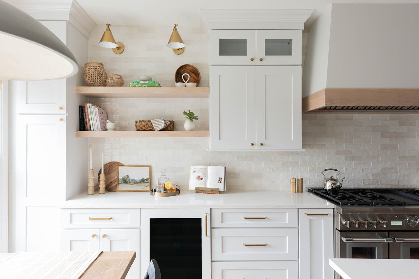 White kitchen with open shelving, cabinets, and a range.