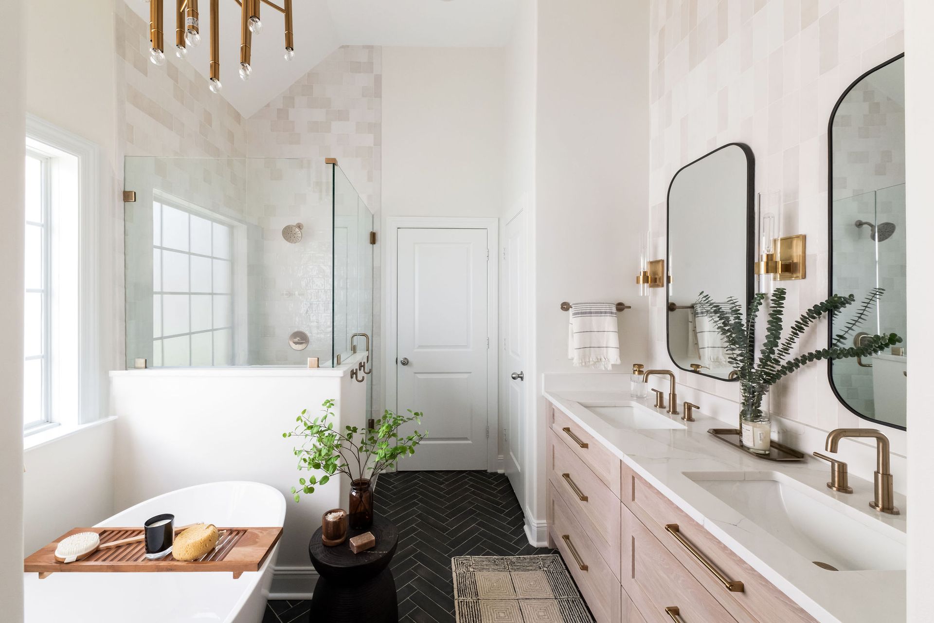 Modern bathroom with marble countertops, wood vanity, and gold accents.