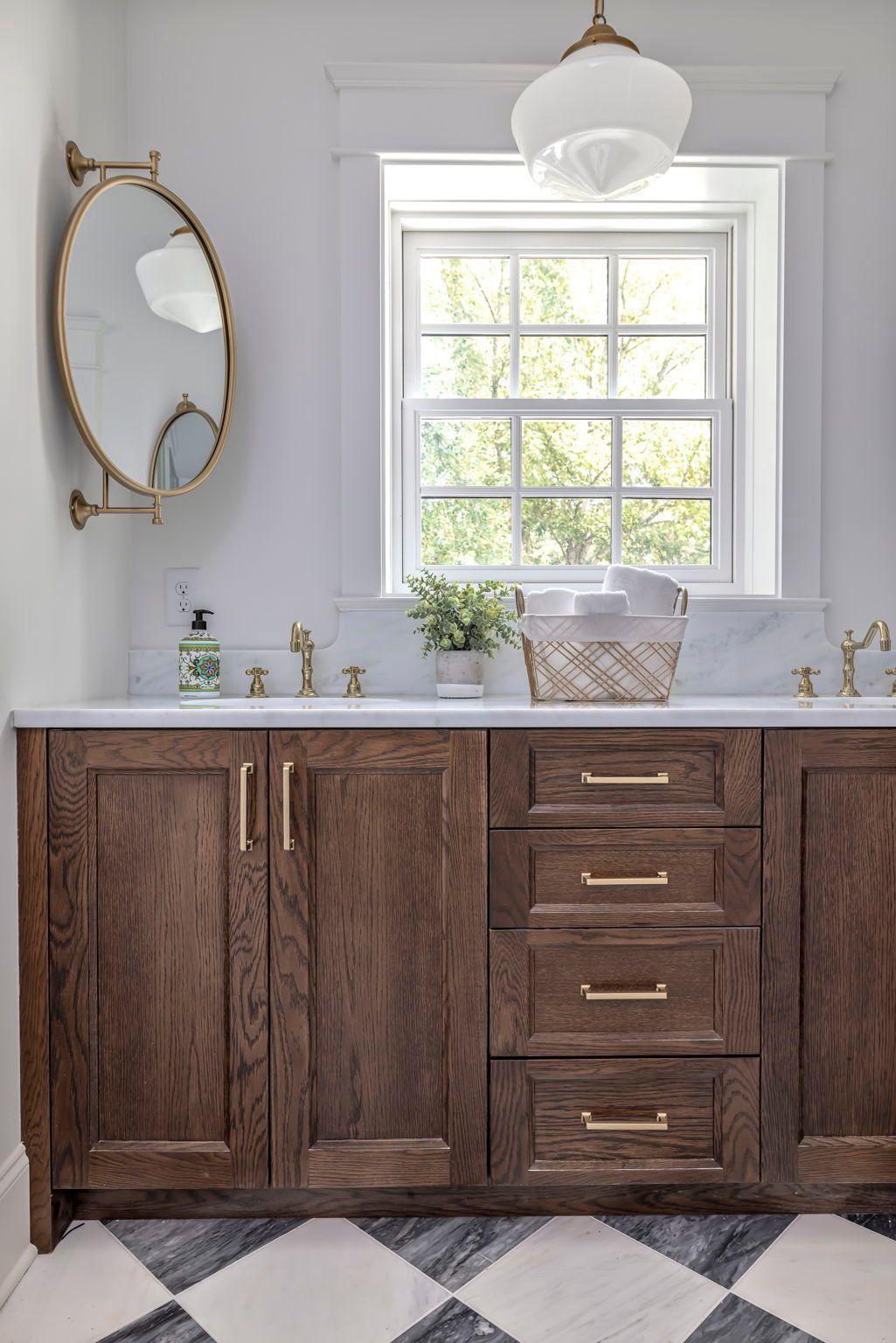 Bathroom with dark wood vanity, marble countertop, brass fixtures, and checkered floor.