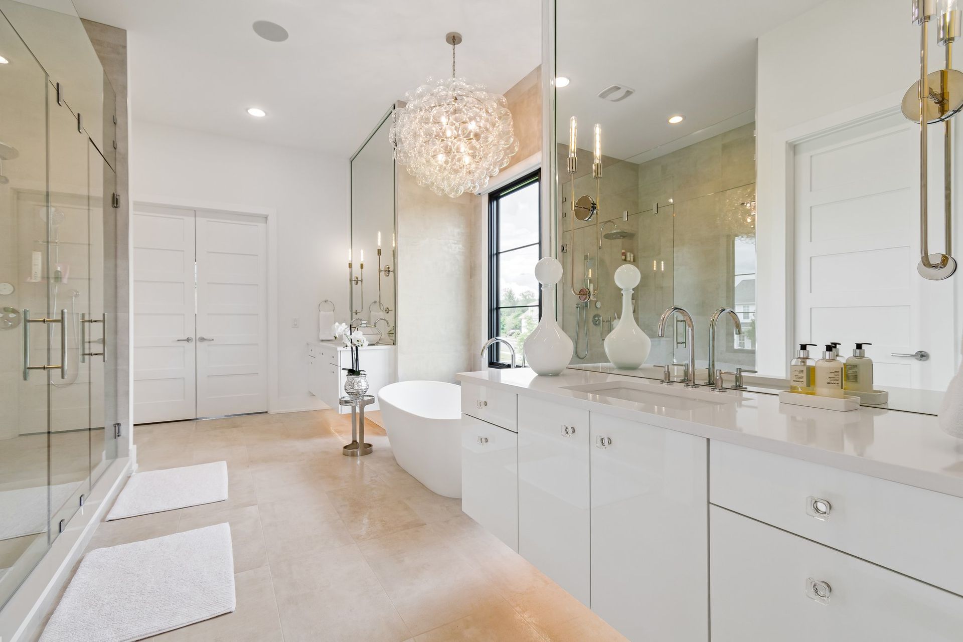 Bright, modern bathroom with white cabinetry, a freestanding tub, and a large shower.