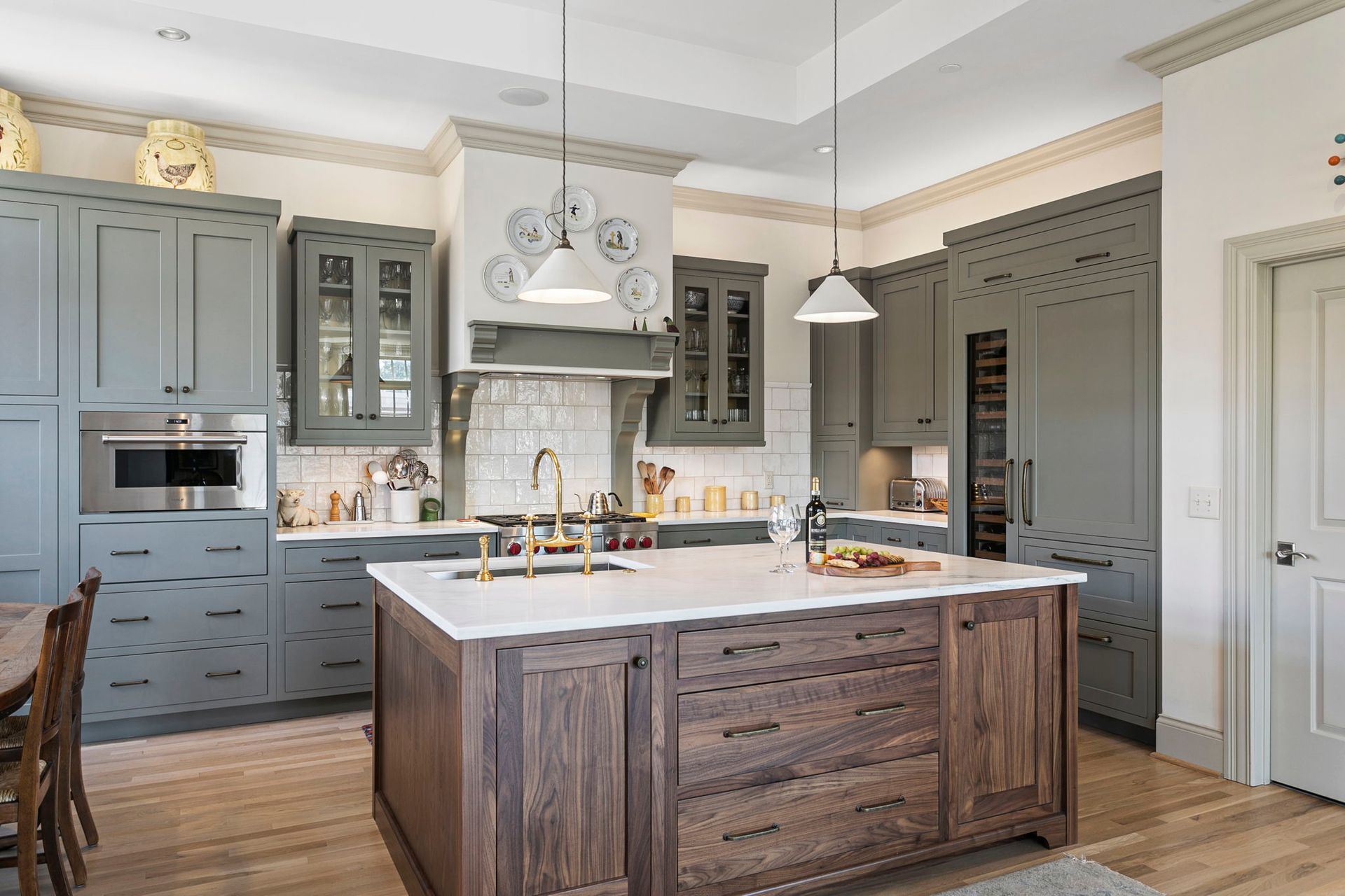 Elegant kitchen with gray cabinets, wooden island, white countertops, and light wood floors.