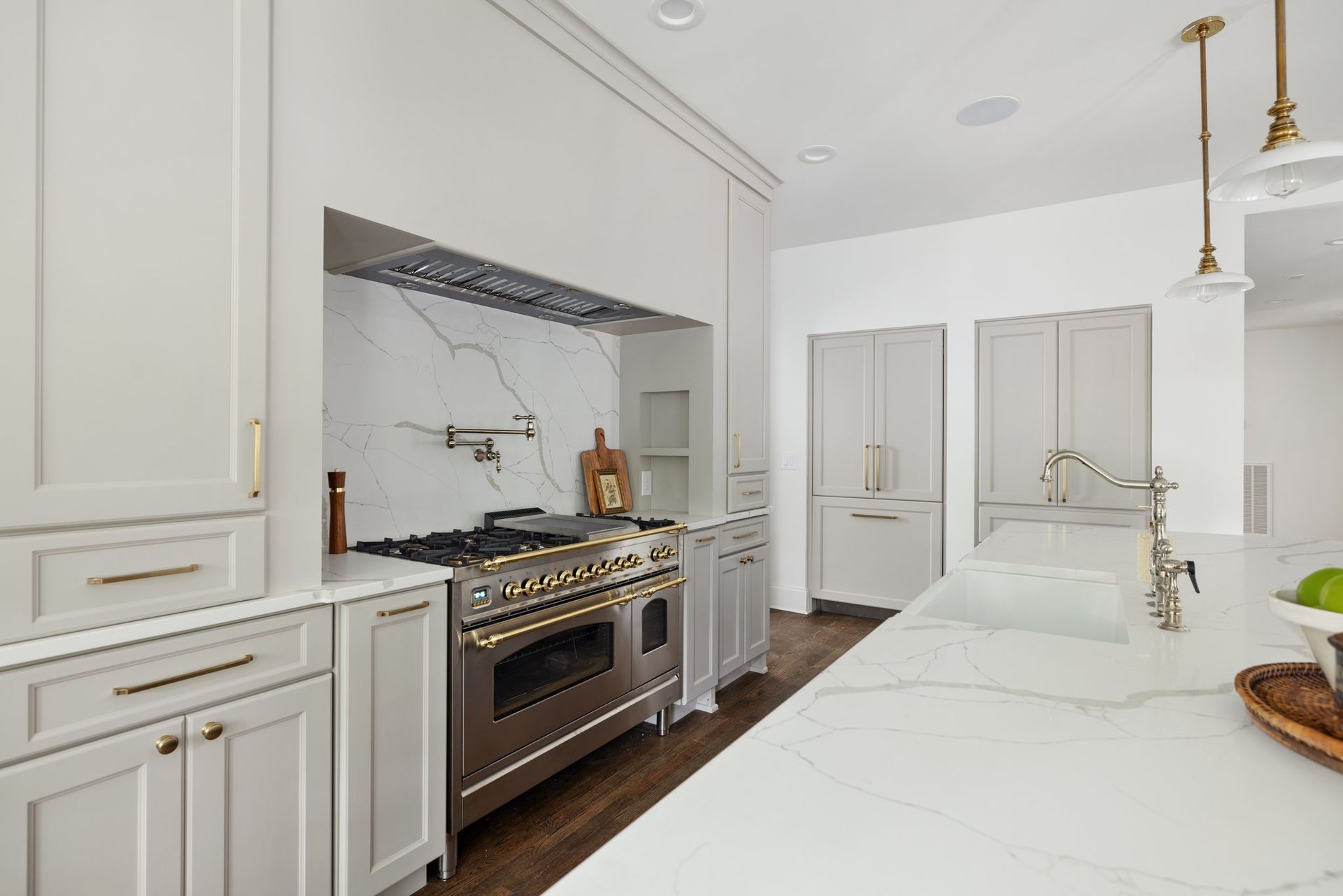 Kitchen with stainless steel stove, white countertops, and light gray cabinetry.