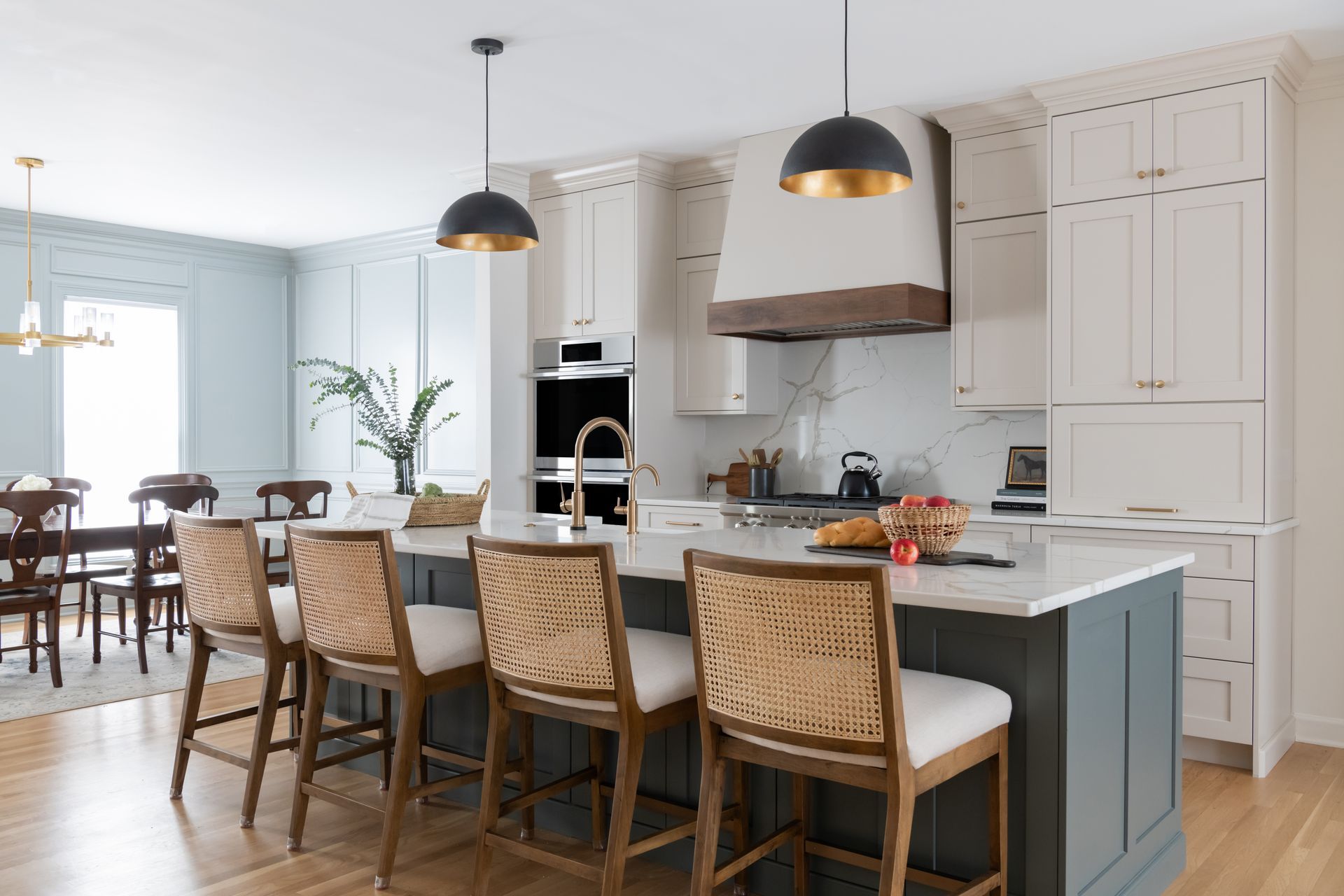 Modern kitchen with island and bar stools, white cabinets, and blue-gray island.